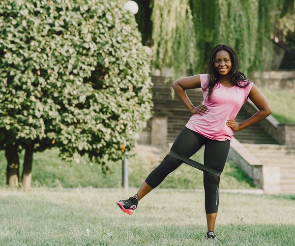 Smiling person stretching after a successful cardio workout outdoors.